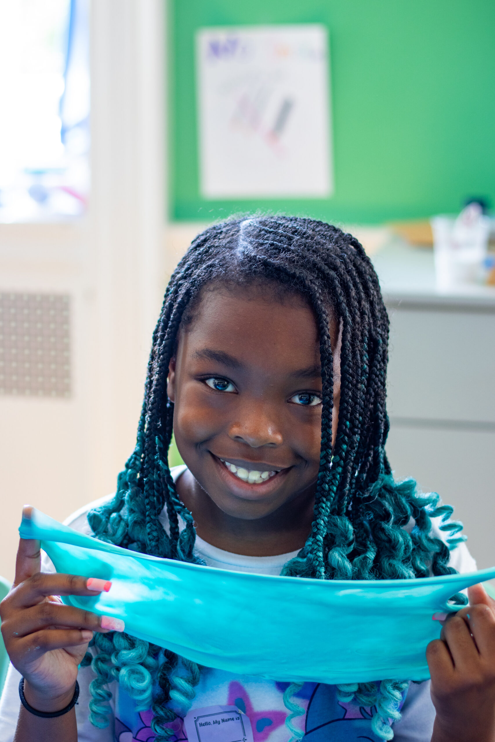 A camper smiles while holding blue slime.