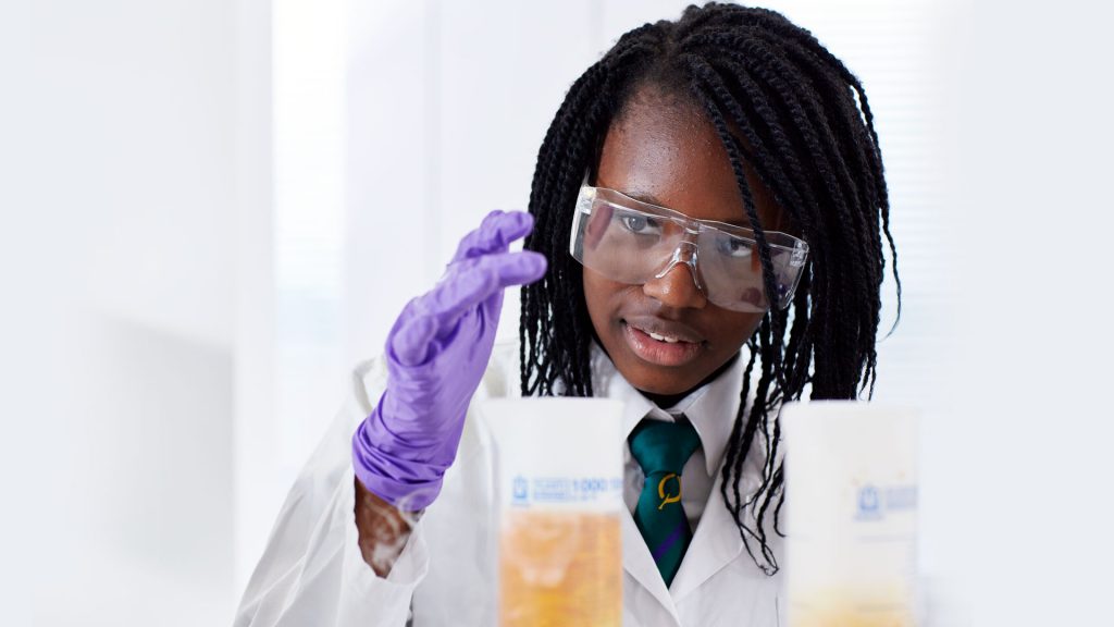 Girl in lab coat and goggles.