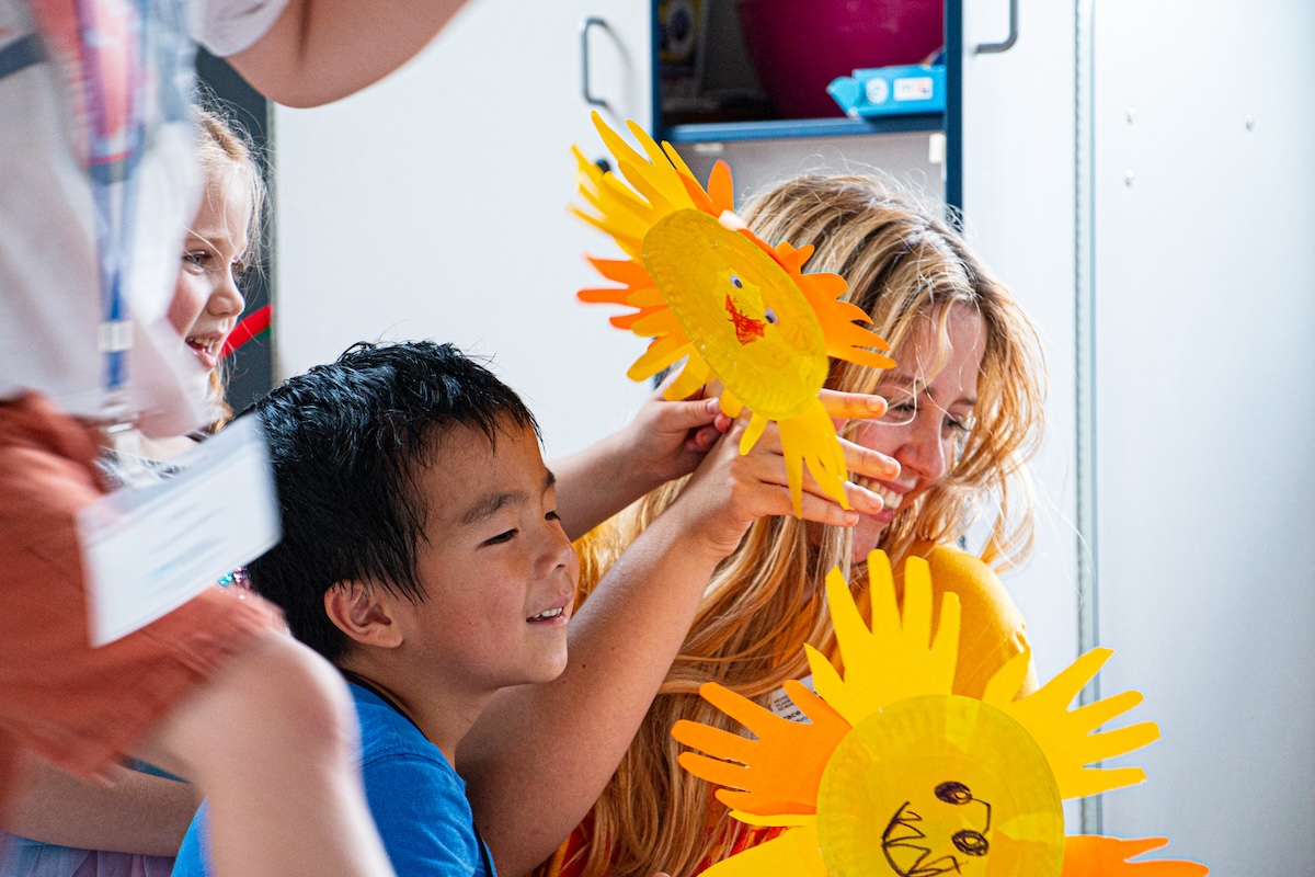 Children hold up paper suns.