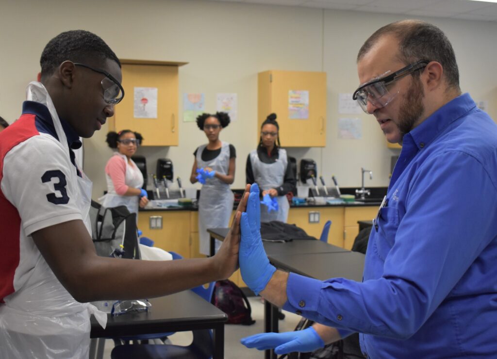 Lab to Life educator with student checking glove size