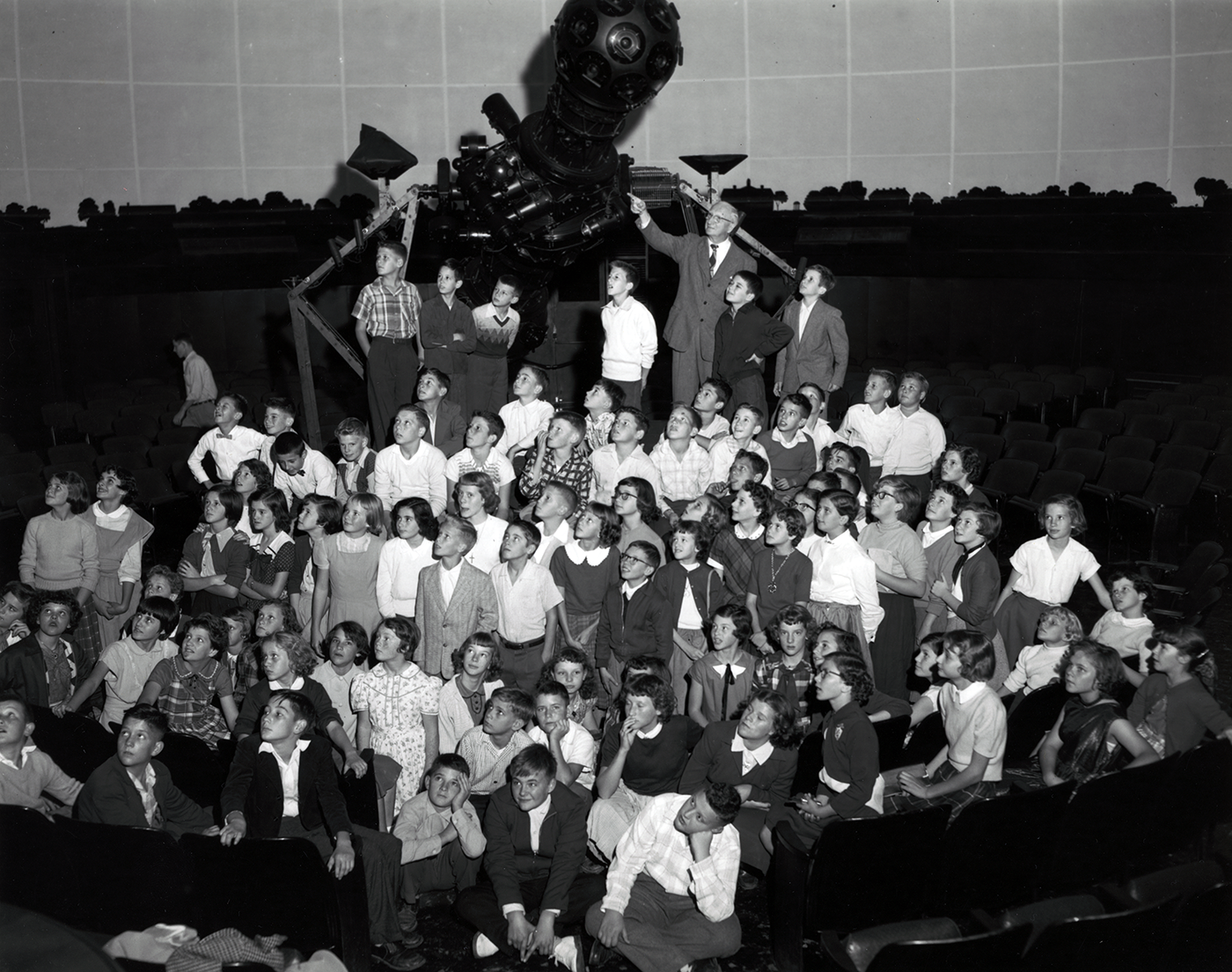 A group of school students in front of the Zeiss projector at Morehead Planetarium.