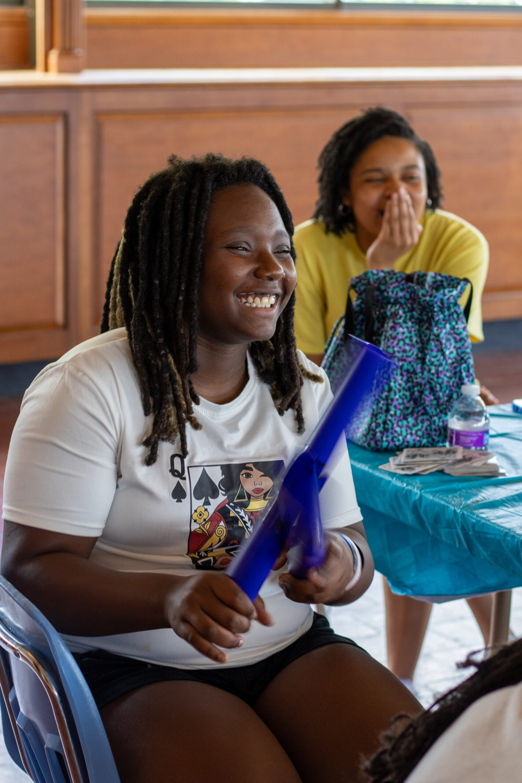 A child smiles while hitting two sound sticks together.