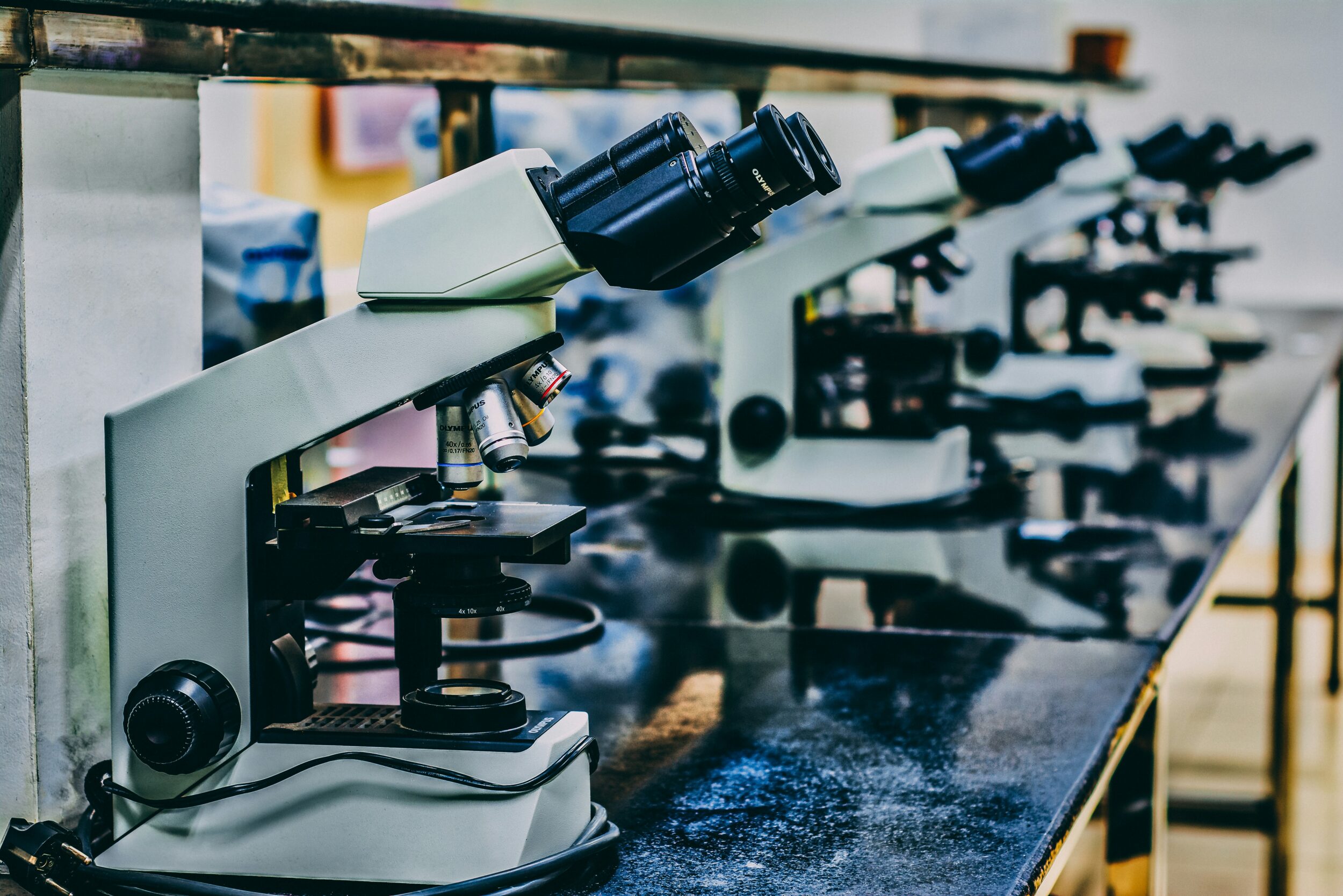 A line of microscopes in a empty laboratory. 