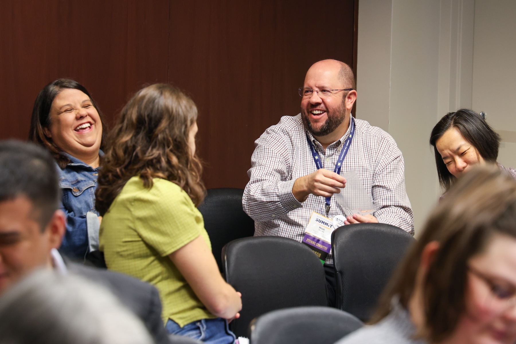 Professionals chat and laugh.