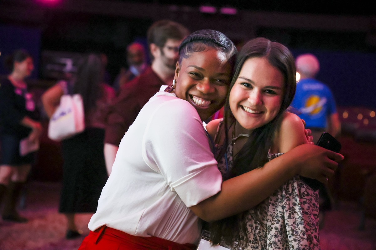 Two people hug and smile.