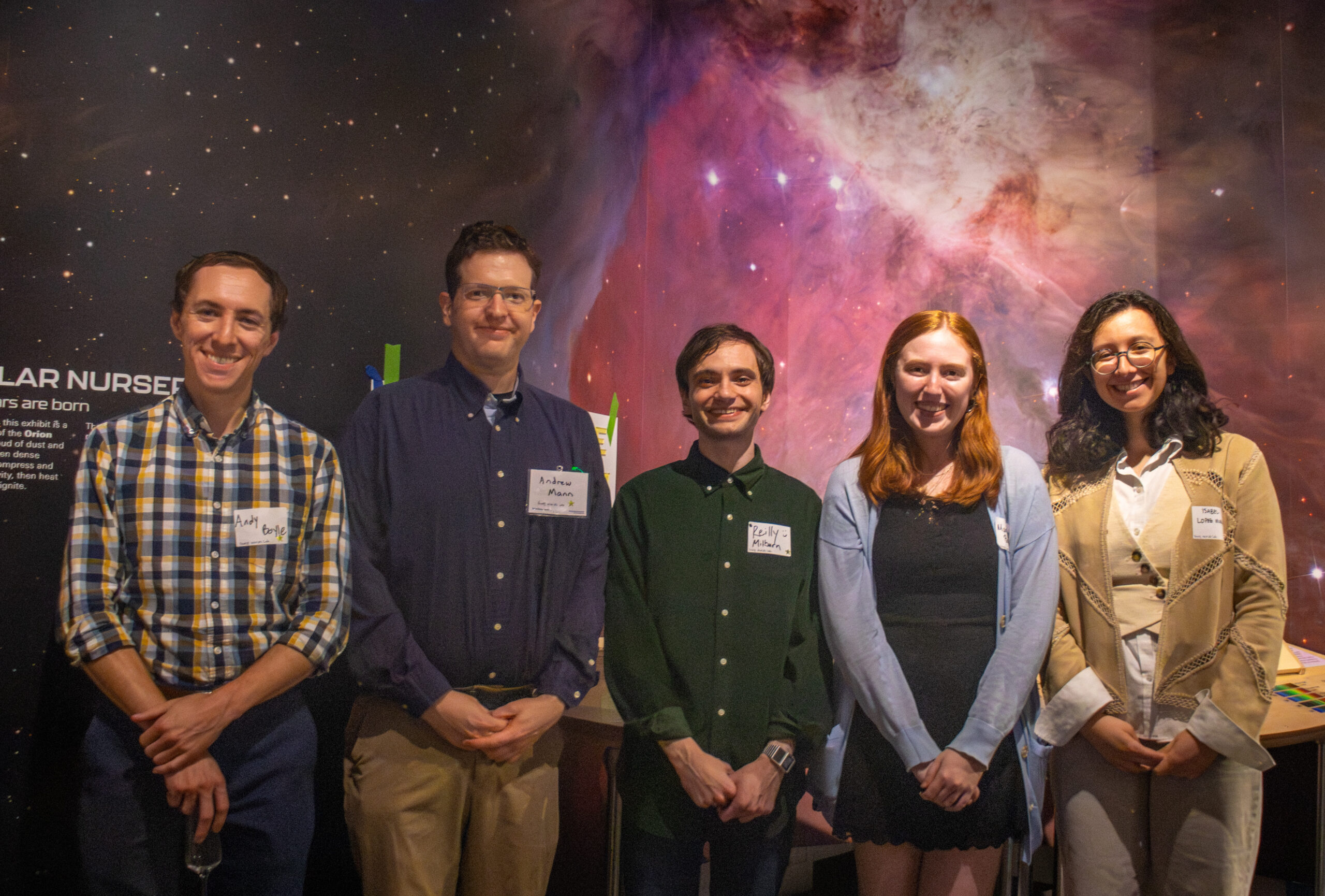 Young Worlds Lab members smile and pose in front of the Hidden Lives of Stars exhibit.