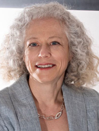 Dr. Andrea Bozoki smiles in a gray suit.