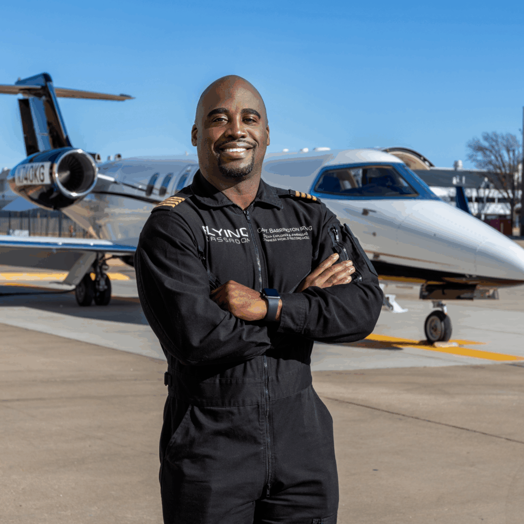 Captain Barrington smiles in front of an airplane.