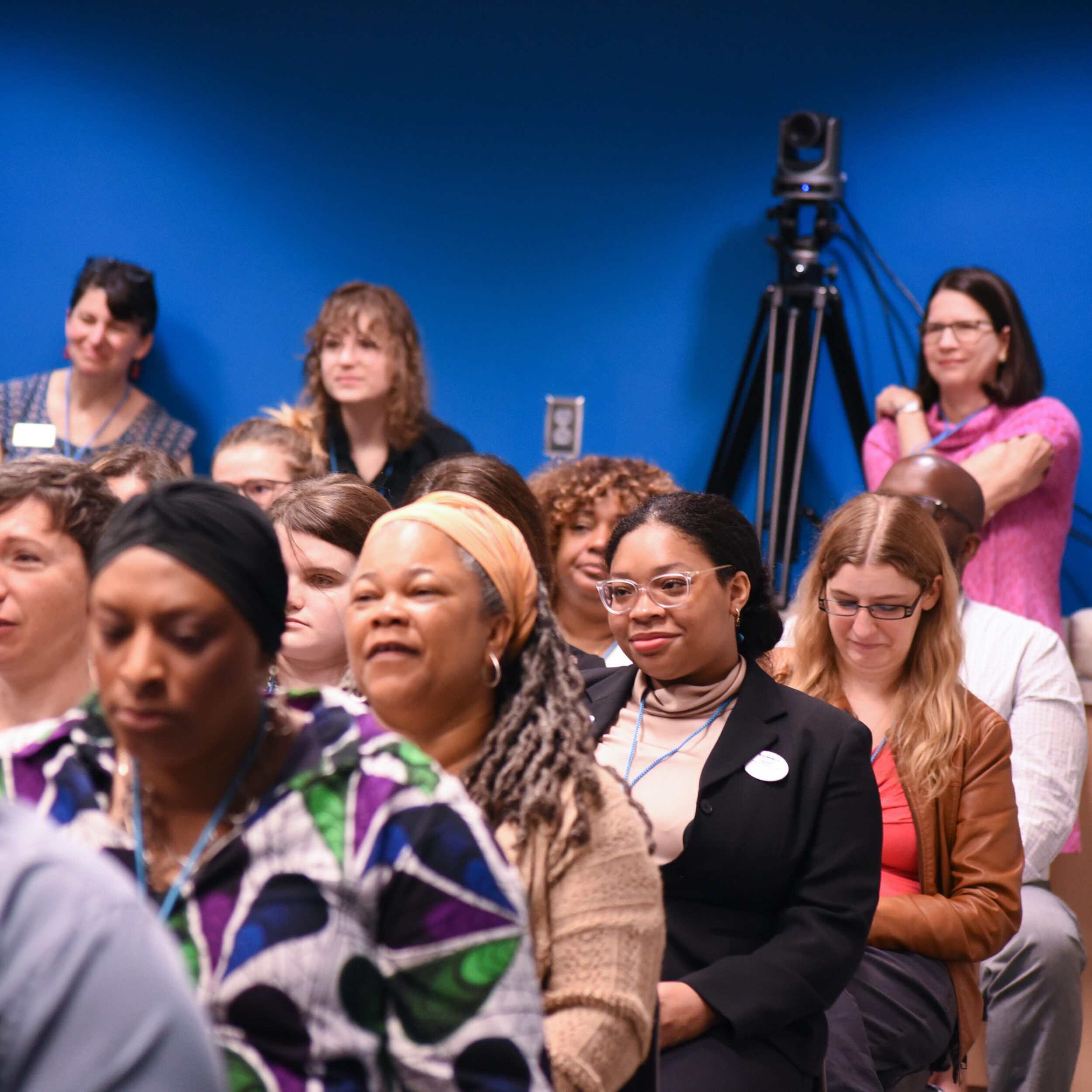 A group of people sit and stand in a conference room.